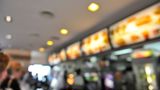 A blurred image of the digital menu in a fast food outlet