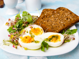 A plate containing a healthy breakfast, featuring wholemeal toast and soft-boiled eggs