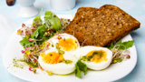 A plate containing a healthy breakfast, featuring wholemeal toast and soft-boiled eggs